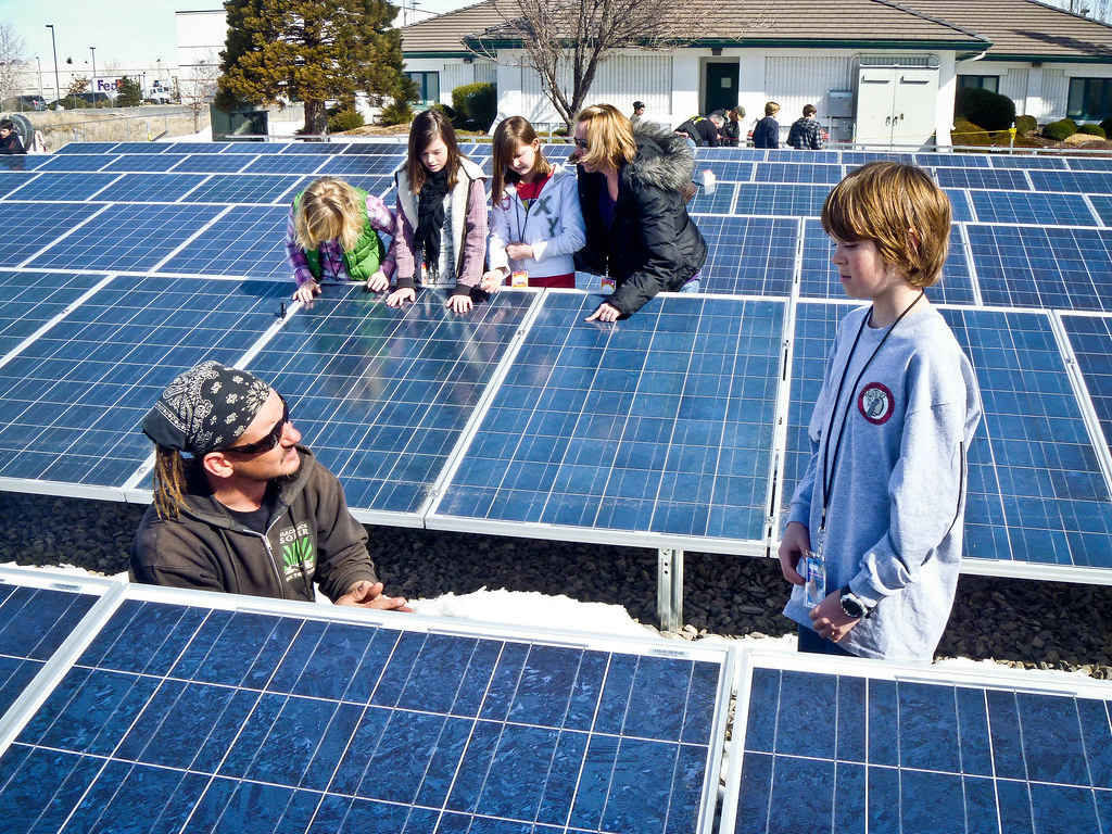 Niños y niñas observando paneles solares
